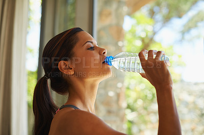 Buy stock photo A young woman holding a bottle of mineral water 