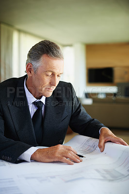 Buy stock photo Reading, blueprint and mature man in office, finance and  check for tax of investment in property. Real estate, realtor and executive of business with floor plan and paperwork for budget on desk