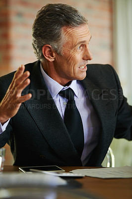 Buy stock photo An expressive businessman having a discussion during a meeting