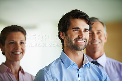 Buy stock photo Smiling coworkers standing together and looking away