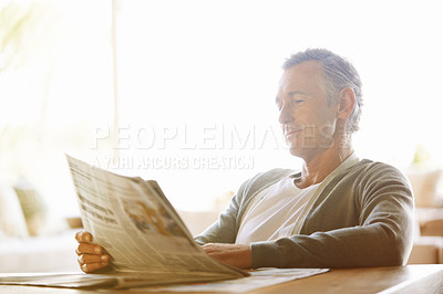 Buy stock photo Mature, man and newspaper for reading in house, relax and information or articles in morning with coffee. News, breakfast table and rest and calm for entertainment pages, current events in apartment