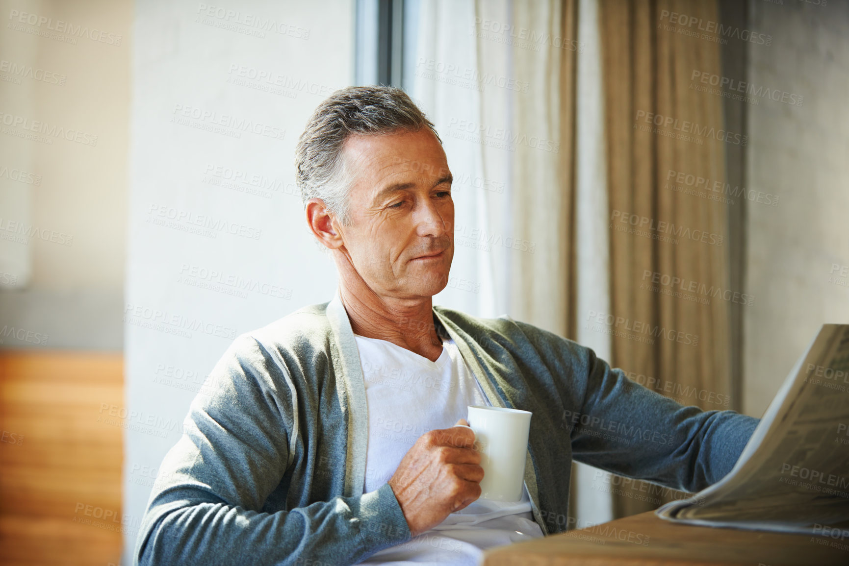 Buy stock photo Mature, man and newspaper for reading in home, relax and information or articles in morning with coffee. News, breakfast table and rest and calm for entertainment pages, current events in apartment