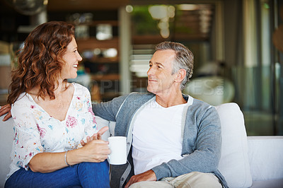 Buy stock photo Mature, coffee or happy couple talking in home living room for conversation or communication in marriage. Smile, drinking tea or woman speaking to man in retirement or discussion to relax together