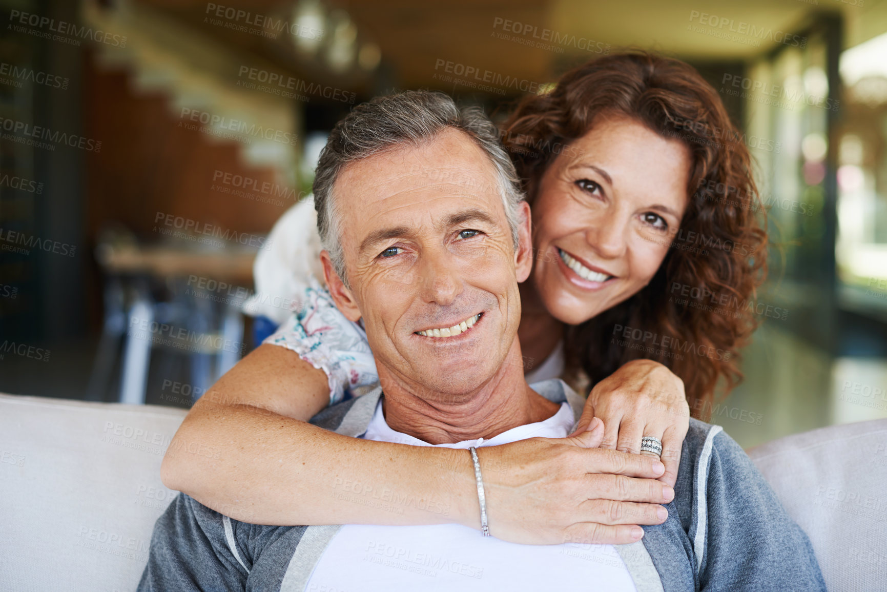 Buy stock photo A handsome mature man being lovingly embraced by his smiling wife