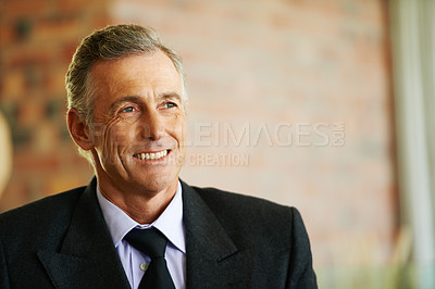 Buy stock photo A handsome mature businessman looking away with a smile