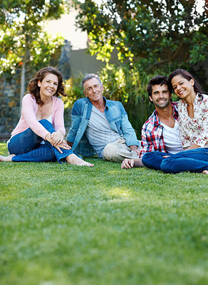 Buy stock photo Happy family, portrait and relax with love on grass field for bonding, weekend or holiday together in backyard. Mother, father and couple chilling at park on summer break, date or gathering in nature