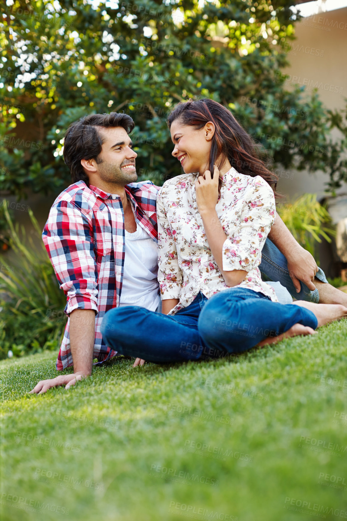 Buy stock photo Outdoor, bonding and love for couple, grass and happy in backyard, relax and romance for people in home. Nature, man and woman on ground in park, smile and peace for marriage, honeymoon and rest