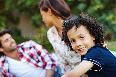 Buy stock photo A cute young family spending time on the grass in the park together