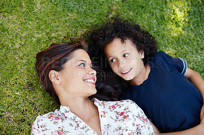 Buy stock photo Garden, mom and child lying on grass to relax in summer, vacation or picnic in holiday. Happy, mother and kid on lawn in backyard with smile on face and talking with love or care in family from above