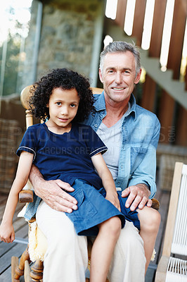 Buy stock photo A smiling grandfather with his grandson seated on his lap