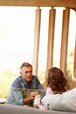 Buy stock photo Mature couple, talking and planning in living space with coffee, bonding and discussing life and marriage in day. Older man, woman and couch at home with together, important and serious conversation