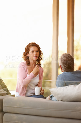 Buy stock photo Mature couple, conversation and bonding with tea on a cabin porch, relationship and trust for discussion. Communication, comfortable and relax, support and marriage over coffee at home by nature