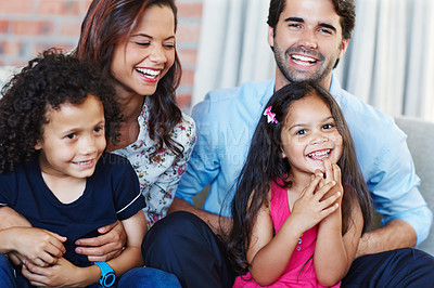 Buy stock photo A happy family sitting on a sofa in their living room