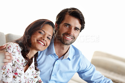 Buy stock photo A young couple embracing each other on the sofa