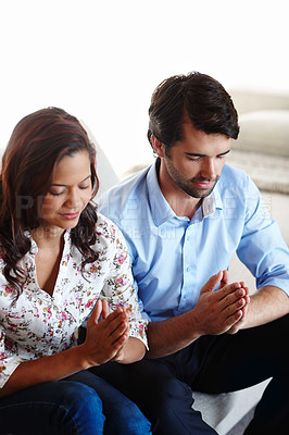 Buy stock photo A young couple sitting together in prayer