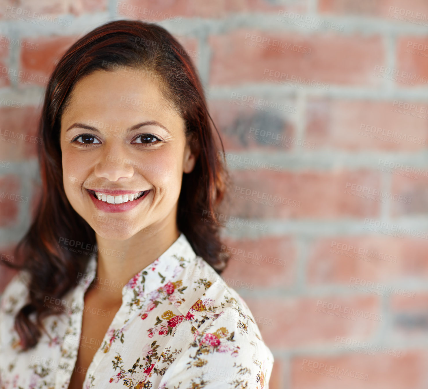 Buy stock photo An attractive ethnic female standing against a brick wall and smiling at the camera