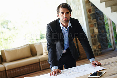 Buy stock photo Young architect revising plans for final approval