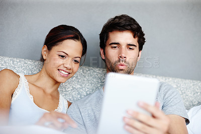 Buy stock photo Morning, woman and man in bed with tablet, reading or online video streaming service in home. Relax, smile and couple in bedroom with digital app for social media, bonding and weekend in apartment