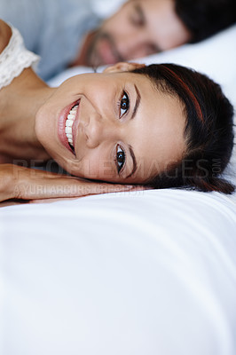 Buy stock photo Smiling young woman lying in bed alongside her boyfriend