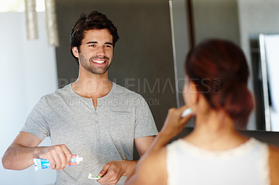 Buy stock photo A handsome man and his girlfriend preparing to brush their teeth in the morning