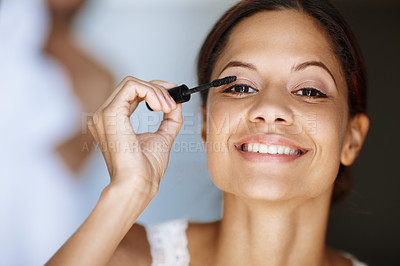 Buy stock photo Attractive young woman applying her mascara in the morning