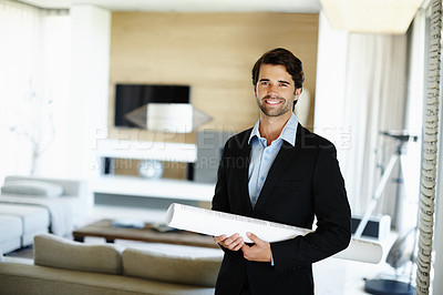 Buy stock photo A handsome young architect wearing a suit and holding some design plans