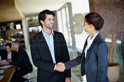 Buy stock photo A smiling businessman shaking hands with a client