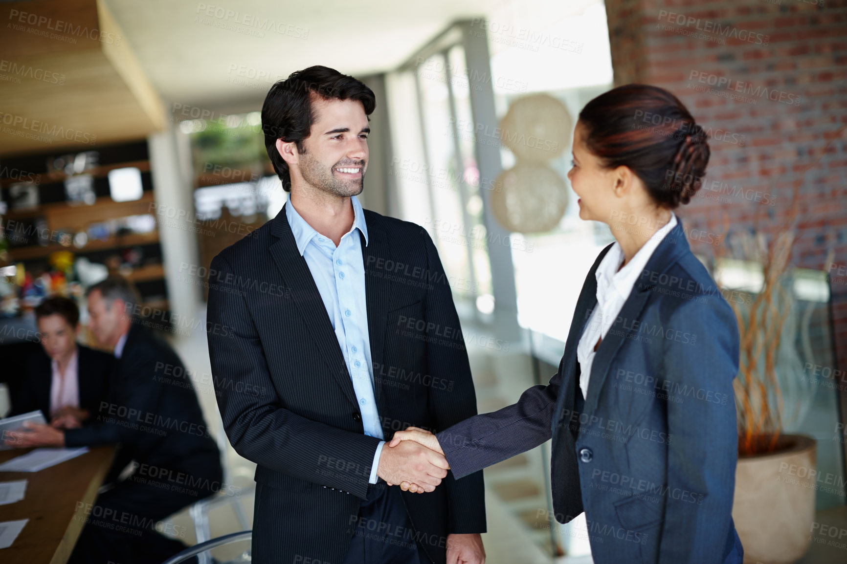 Buy stock photo A smiling businessman shaking hands with a client