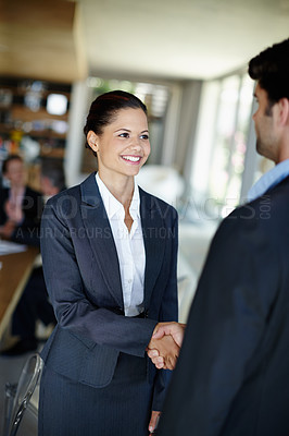 Buy stock photo An attractive young businesswoman shaking hands with a client