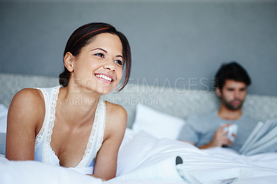 Buy stock photo Morning, relax and woman in bed with magazine, reading and smile for couple bonding in home. Happy, face and girl in bedroom with thinking, wellness and comfort in hotel room, house or apartment