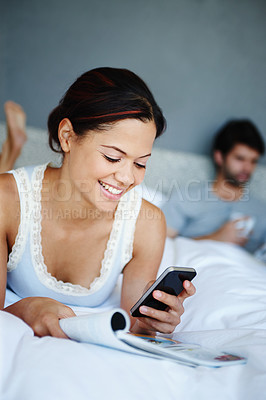 Buy stock photo Woman, happy and smartphone on bed with magazine, online ecommerce and shopping on holiday with man. Couple, relax and bedroom on social media app or texting, web search and morning news in apartment