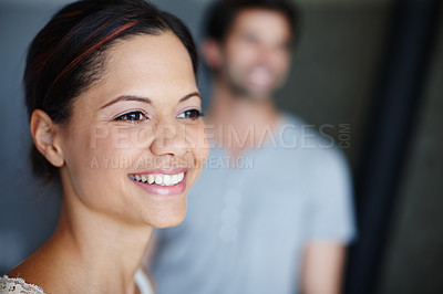 Buy stock photo Shot of a smiling woman with her boyfriend in the background with copyspace