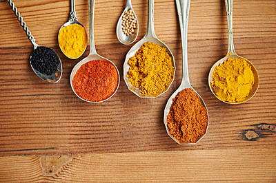 Buy stock photo Spoons, spice and selection of powder for seasoning on kitchen table, turmeric and paprika for meal. Top view, condiments and options for spicy cooking in Indian culture, cumin and food preparation