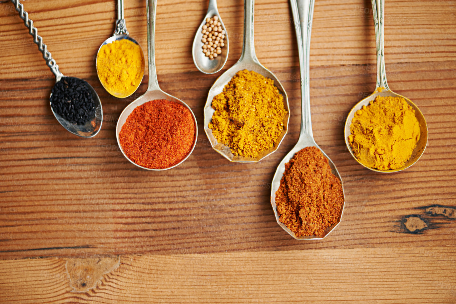 Buy stock photo Spoons, spice and selection of powder for seasoning on kitchen table, turmeric and paprika for meal. Top view, condiments and options for spicy cooking in Indian culture, cumin and food preparation