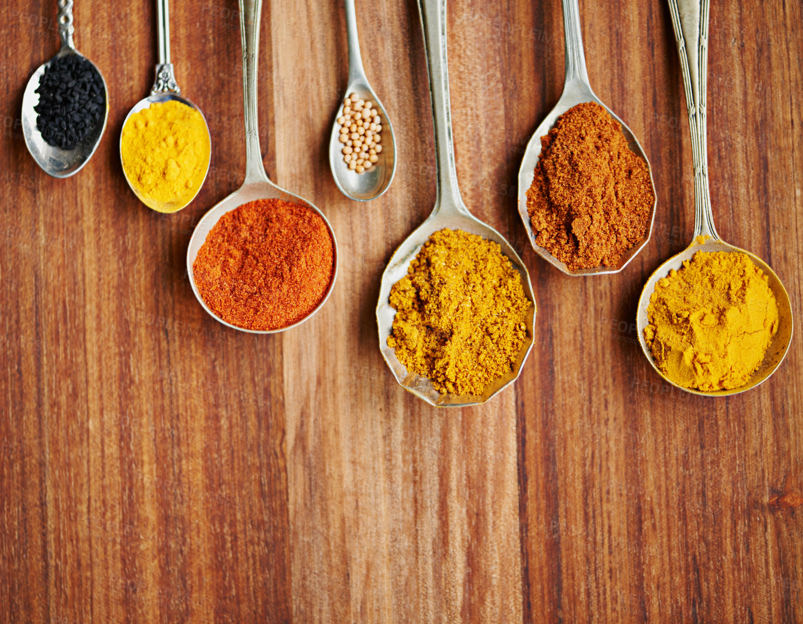 Buy stock photo Spoons, spice and selection of flavor for seasoning on kitchen table, turmeric and paprika for meal. Top view, condiments and options for spicy cooking in Indian culture, cumin and food preparation