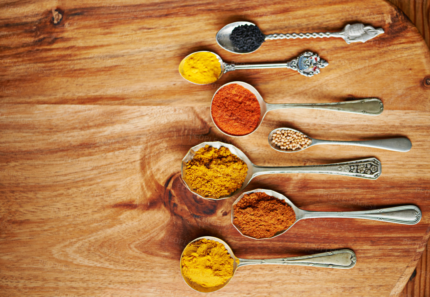 Buy stock photo Spoons, spice and selection of ingredients for seasoning on kitchen table, turmeric and paprika for meal. Top view, condiments and options for cooking in Indian culture, cumin and food preparation