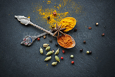 Buy stock photo Above, spices and spoon for flavor and dry ingredient for cooking, cuisine and food on table top for traditional Indian dish. Turmeric and curry powder with peppercorns and cardamom for hot dinner