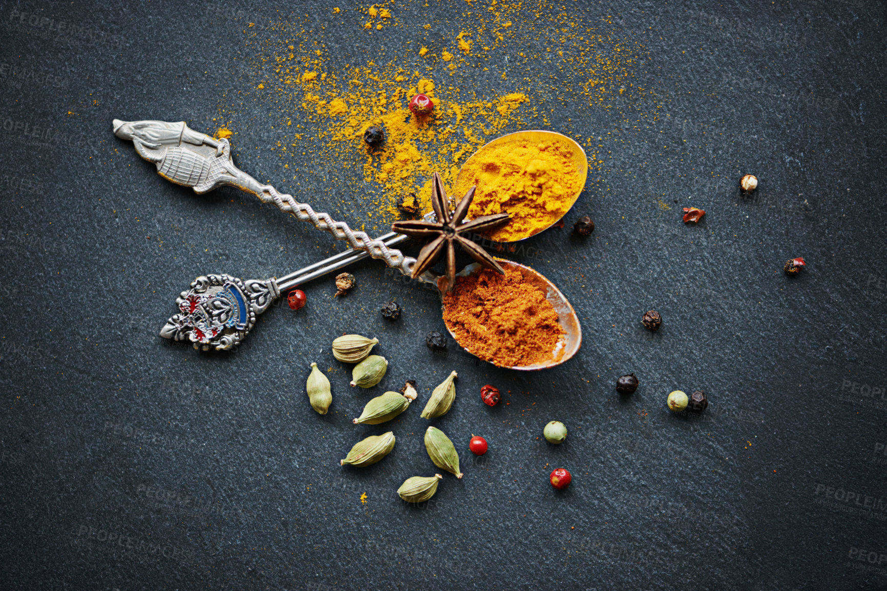 Buy stock photo Above, spices and spoon for flavor and dry ingredient for cooking, cuisine and food on table top for traditional Indian dish. Turmeric and curry powder with peppercorns and cardamom for hot dinner