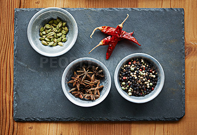 Buy stock photo Chilli, ingredients and spices in bowl above on board for cooking for cuisine, meal and lunch. Condiments, seasoning and dried pepper for gourmet dinner with cardamon seeds, star anise and peppercorn