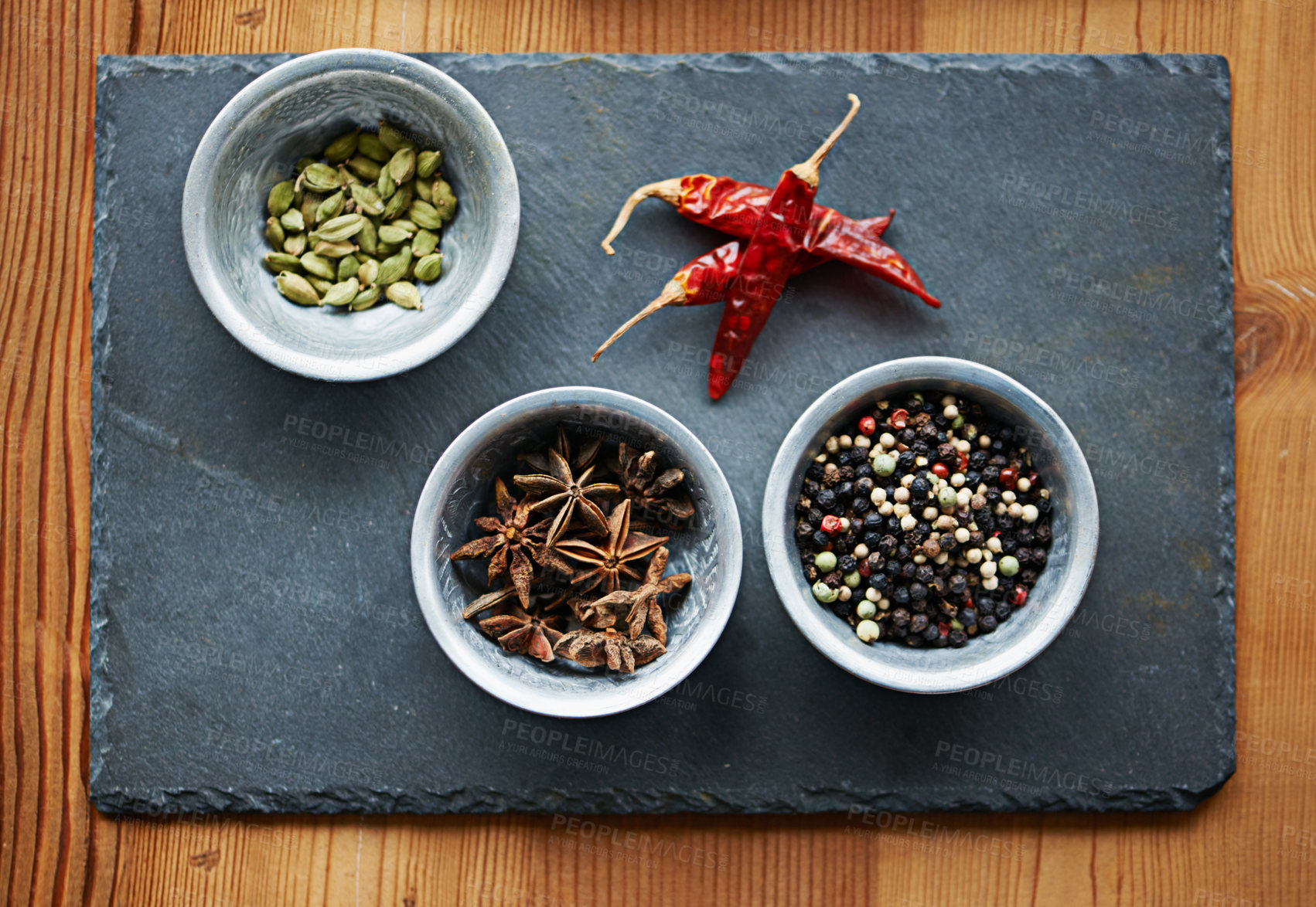 Buy stock photo Chilli, ingredients and spices in bowl above on board for cooking for cuisine, meal and lunch. Condiments, seasoning and dried pepper for gourmet dinner with cardamon seeds, star anise and peppercorn