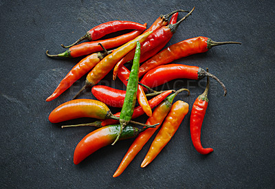 Buy stock photo Chilli, pepper and top view of vegetable for food, ingredient or spices for nutrition and flavor on dark background. Seasoning, heat and organic produce on counter top, fresh for cuisine and catering