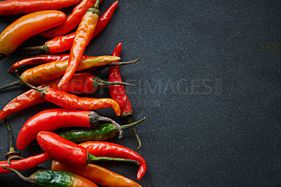 Buy stock photo High angle shot of fresh red chillies on a kitchen counter