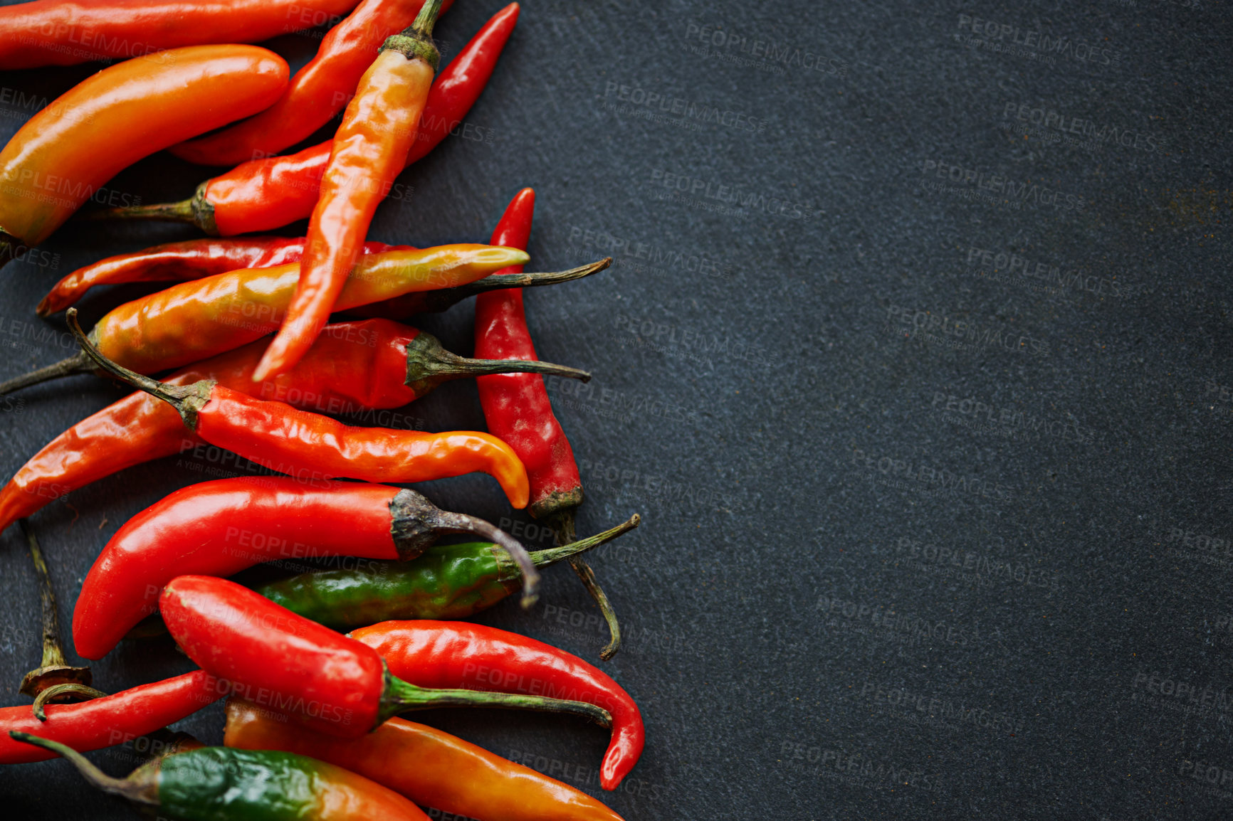 Buy stock photo High angle shot of fresh red chillies on a kitchen counter