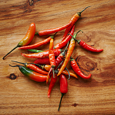 Buy stock photo Above, chilli and board for capsicum, spices and flavor for dry ingredient in cooking, cuisine and food. Paprika, cayenne or condiment on counter and spicy with red for pepper or heat in dish meal
