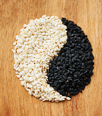 Buy stock photo Yin yang, seeds and food with Asian symbol for balance in diet, nutrition and health with sign on wood table. Natural, ingredients and shape for wellness, spiritual tradition and different cuisine