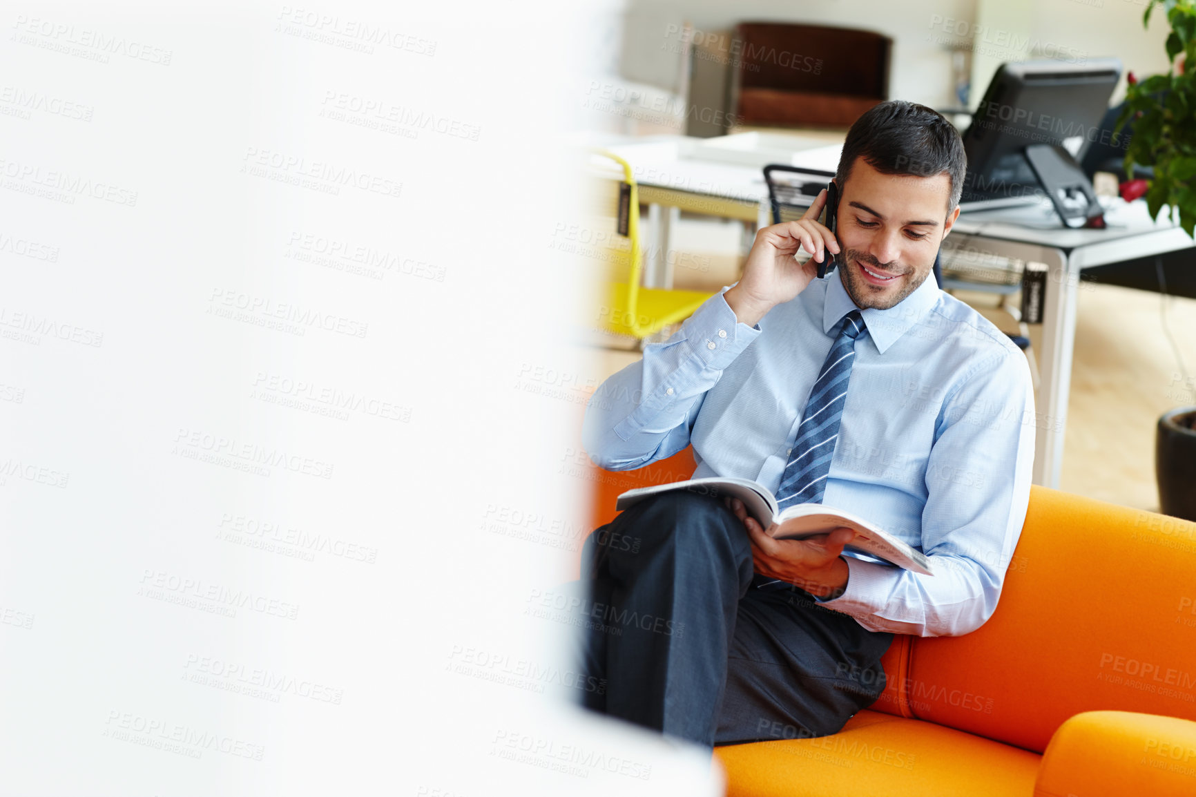 Buy stock photo Businessman, reading and magazine with phone call on sofa for discussion, proposal or article at office. Happy man or employee talking on mobile smartphone with book for story, news or business cover