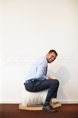 Buy stock photo Portrait, smile and businessman on rocking toy for funny comedy on wall mockup space in office. Happy, comic and goofy professional employee riding sheep for silly joke, crazy or laughing in company