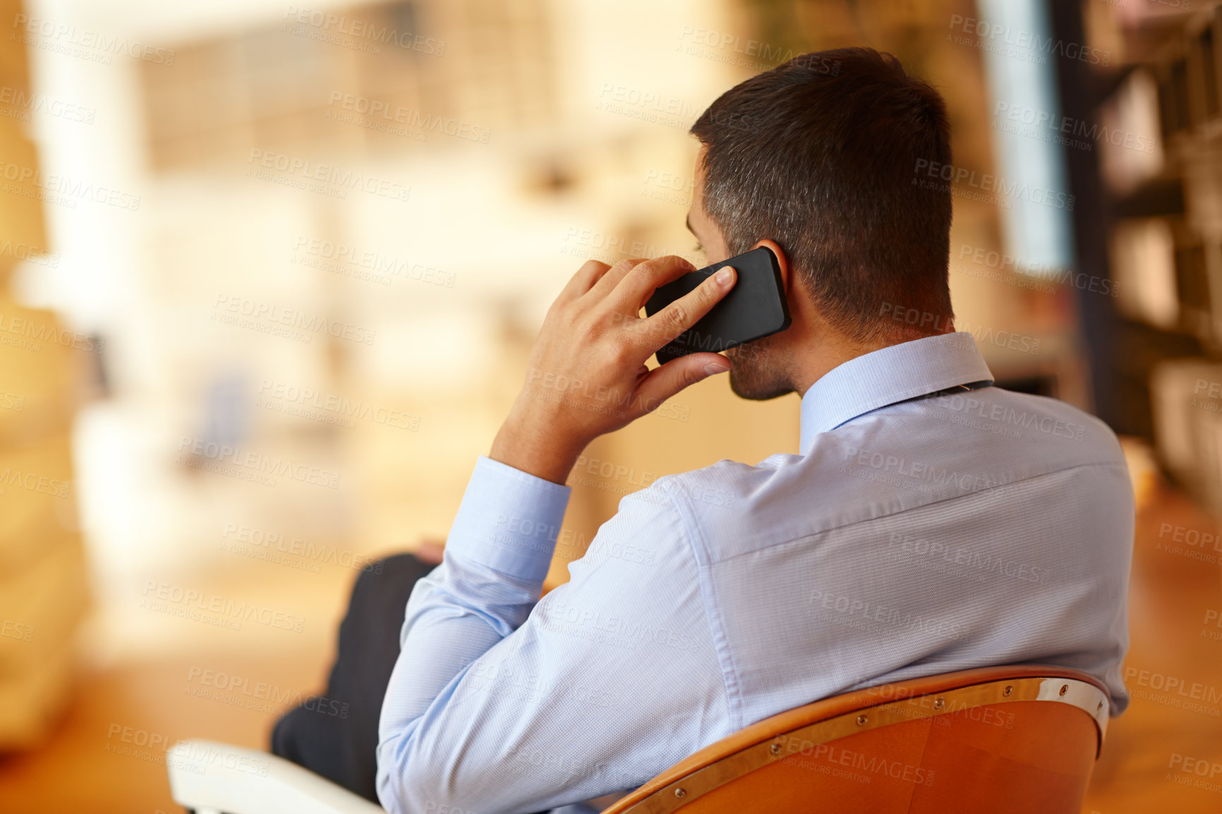 Buy stock photo A young businessman making use of his smartphone