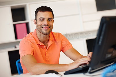 Buy stock photo Portrait of a handsome businessman using a desktop computer at his desk in an office at work. One happy male businessperson using a pc sitting at a table. Confident entrepreneur typing an email