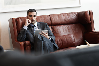 Buy stock photo Businessman, serious and tablet on sofa in office or waiting room for appointment with lawyer in portrait. Worker, digital or professional on couch with tech for consult with browsing online in Spain